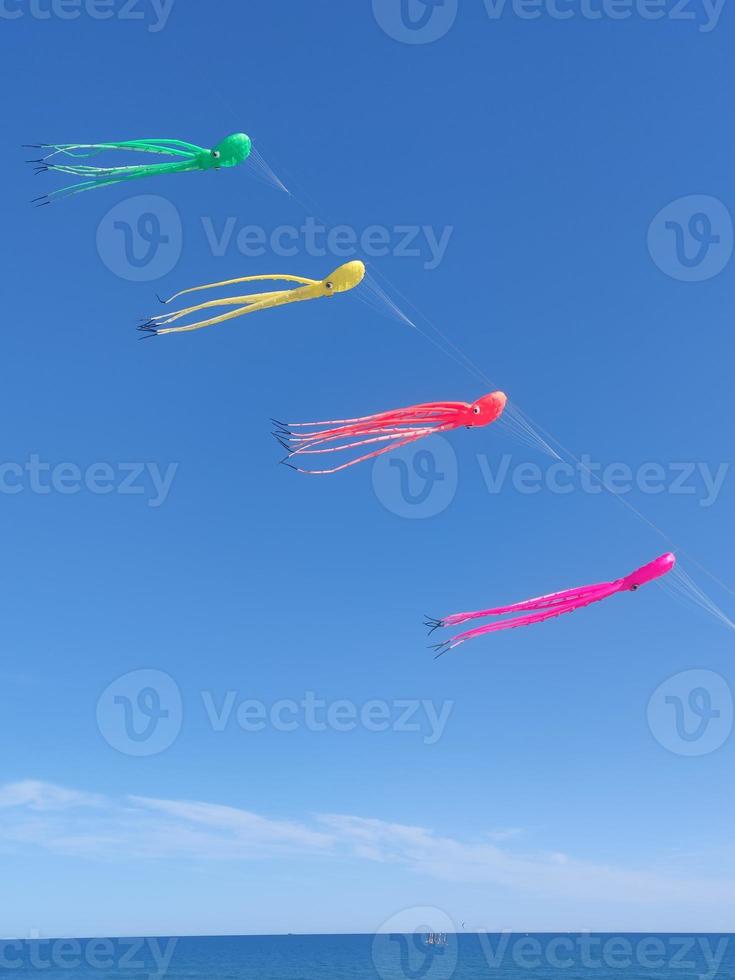 Blue sky with colorful kites in the shape of octopuses photo