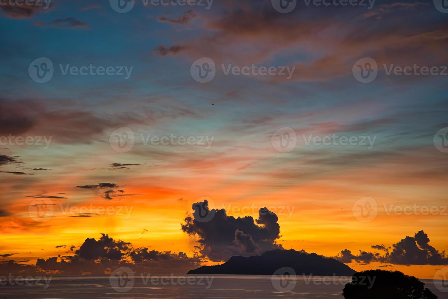 Golden hour at beau vallon beach, silhouette island with nice cloud formation photo