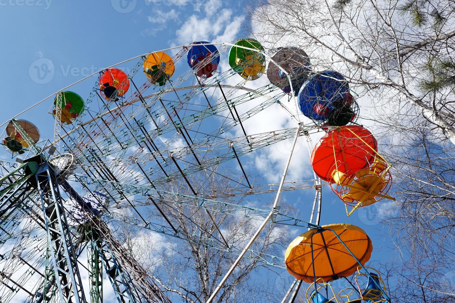 ferris rueda en el frío estación, arboles sin hojas, en contra el antecedentes de un cielo con nubes foto