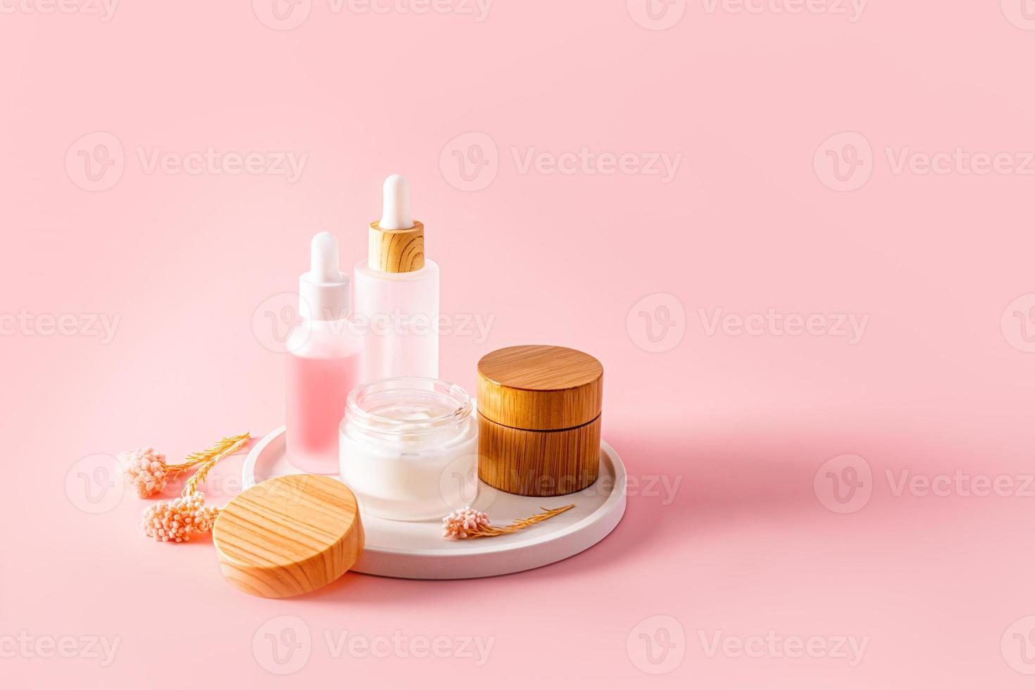 un conjunto de cosmético productos para cara y cuerpo piel cuidado. mate botellas de suero y un abierto tarro de crema. natural productos cosméticos sitio para texto. foto