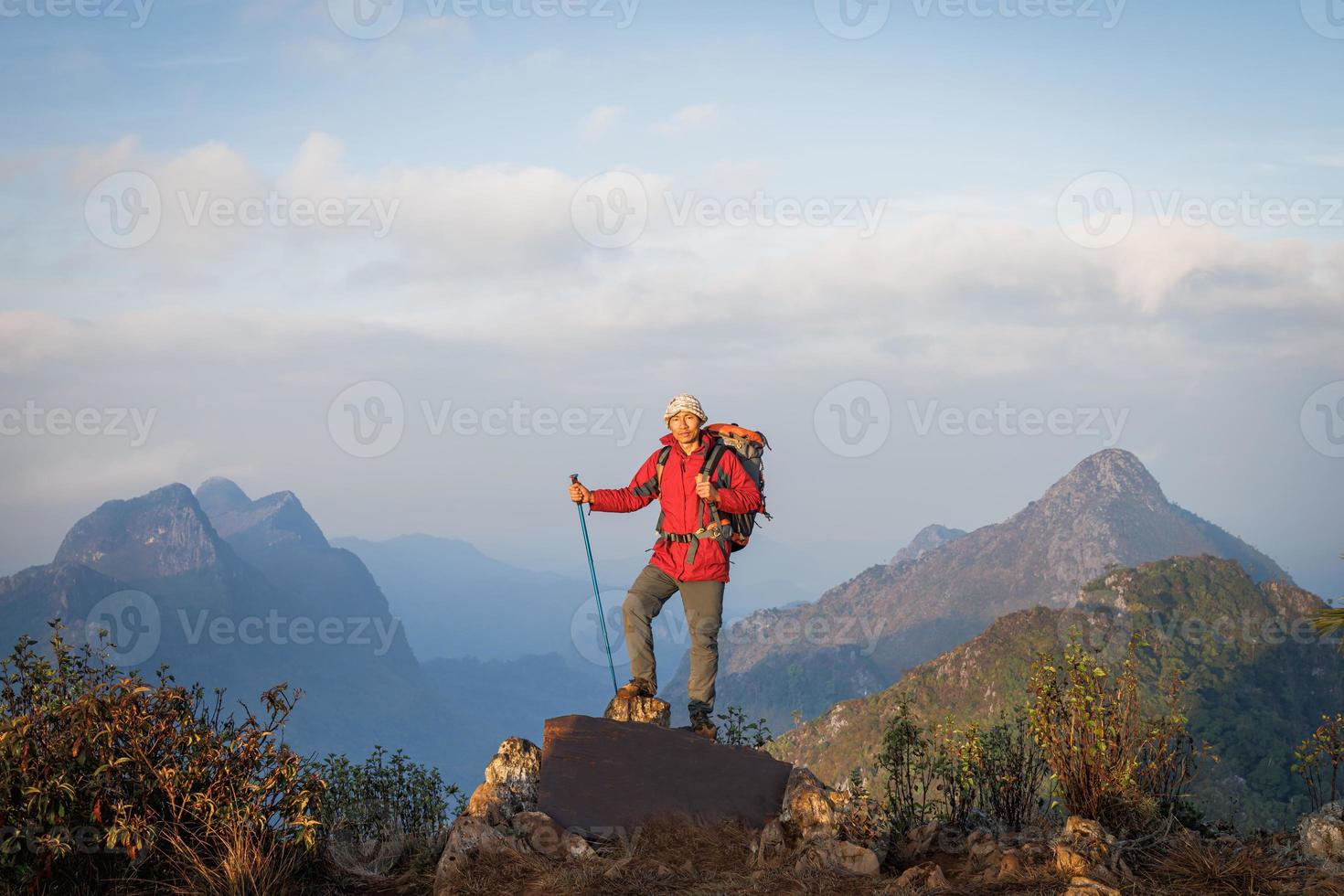 Young man with backpack  on top of mountain, Hiking and tourism concepts. photo
