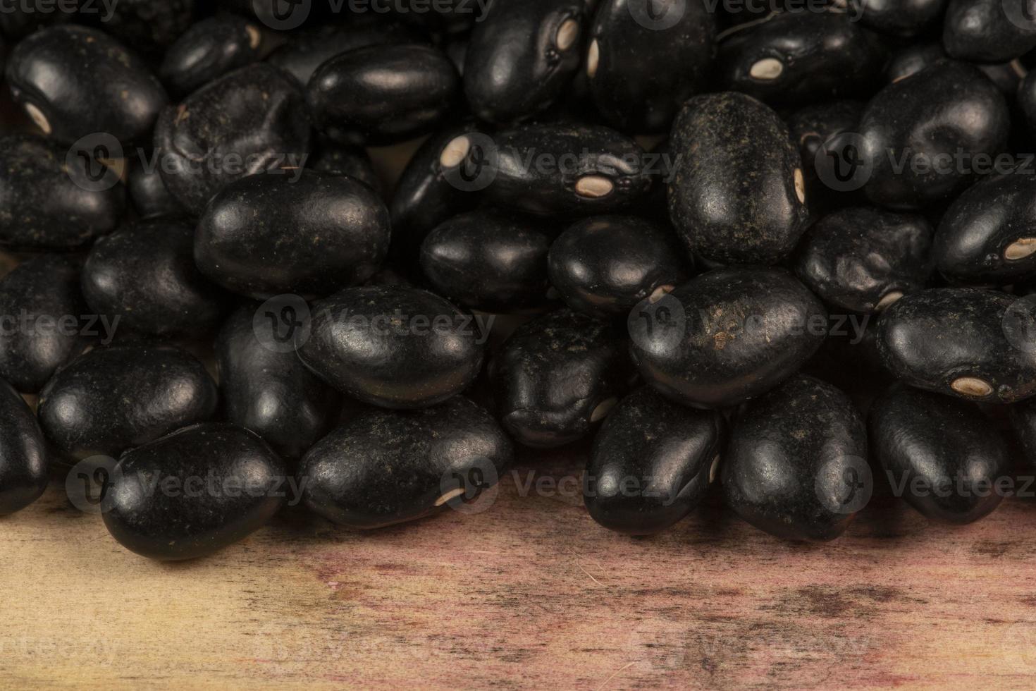 montón de negro frijoles dispersado terminado rústico madera foto