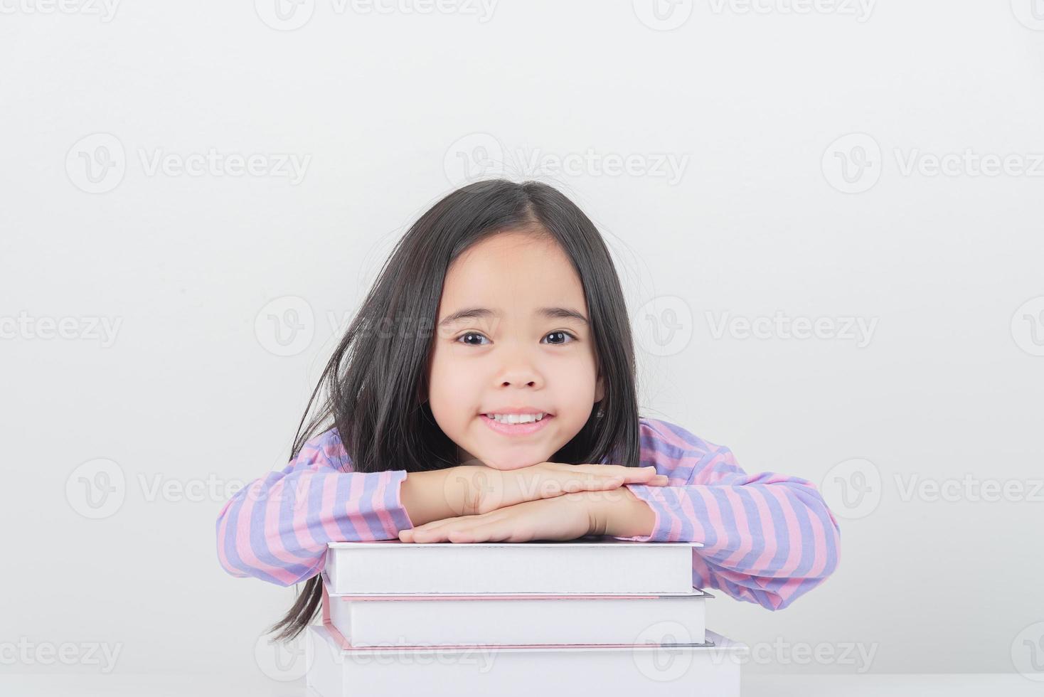 education and school concept - little student girl reading book photo
