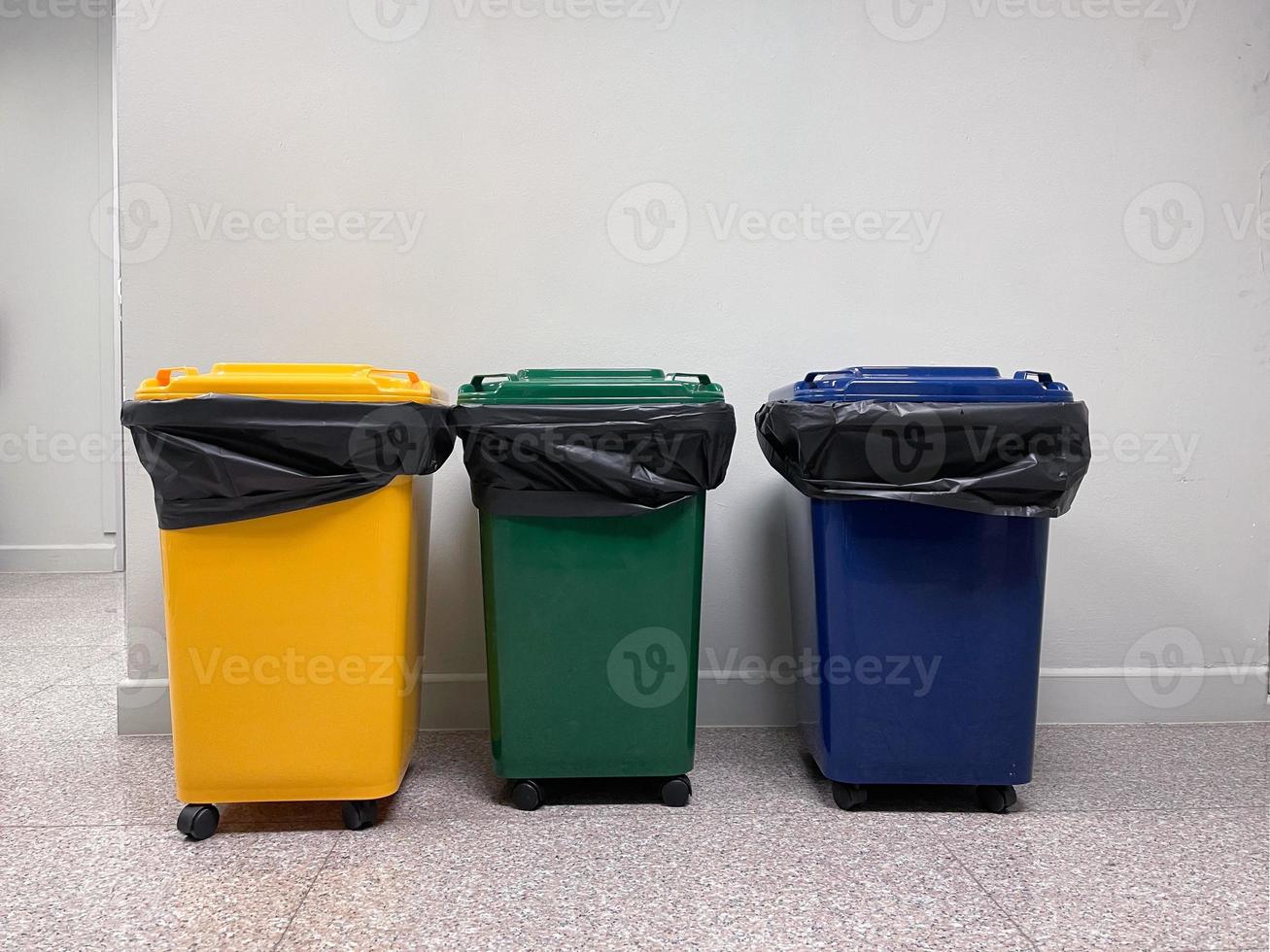 Yellow, green, blue recycle bins in the office. photo