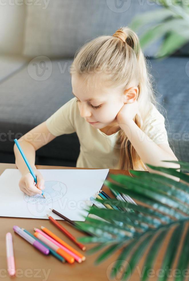 Child girl drawing with colorful pencils photo