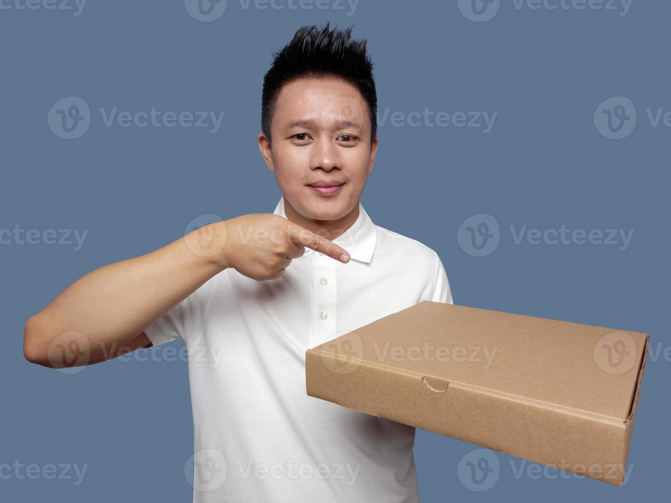 Man holding cardboard box and pointing isolated on plain background photo