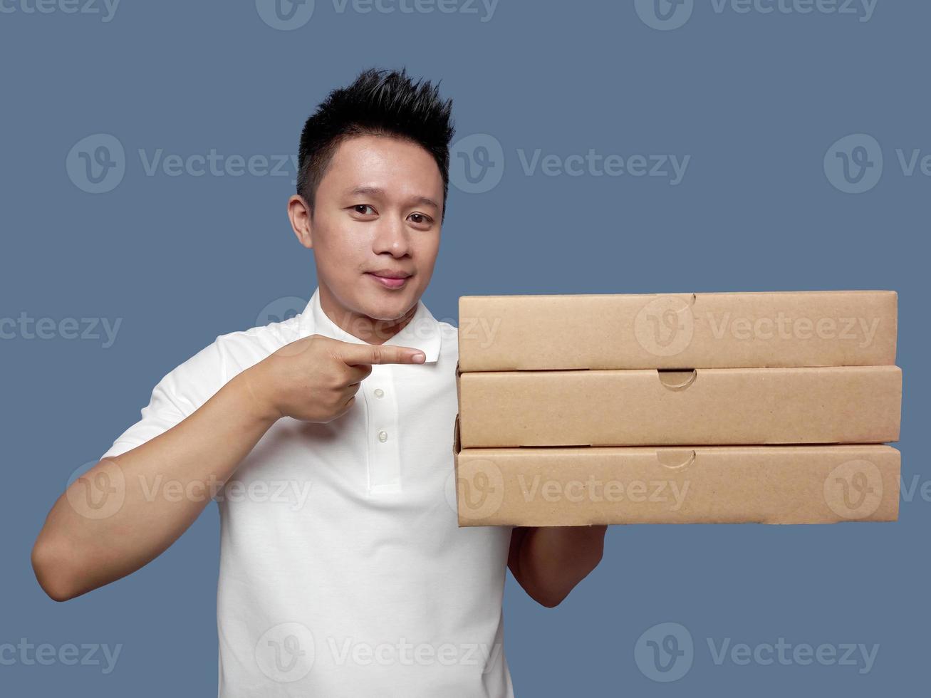 Man holding pizza box and pointing isolated on plain background. photo