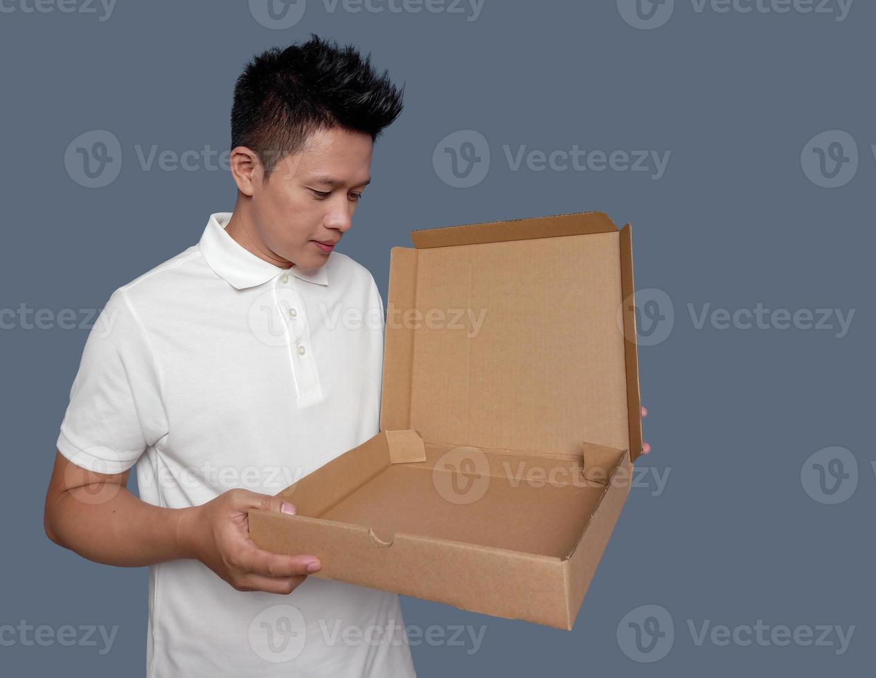 Man is holding and opening an empty cardboard box isolated on plain background photo