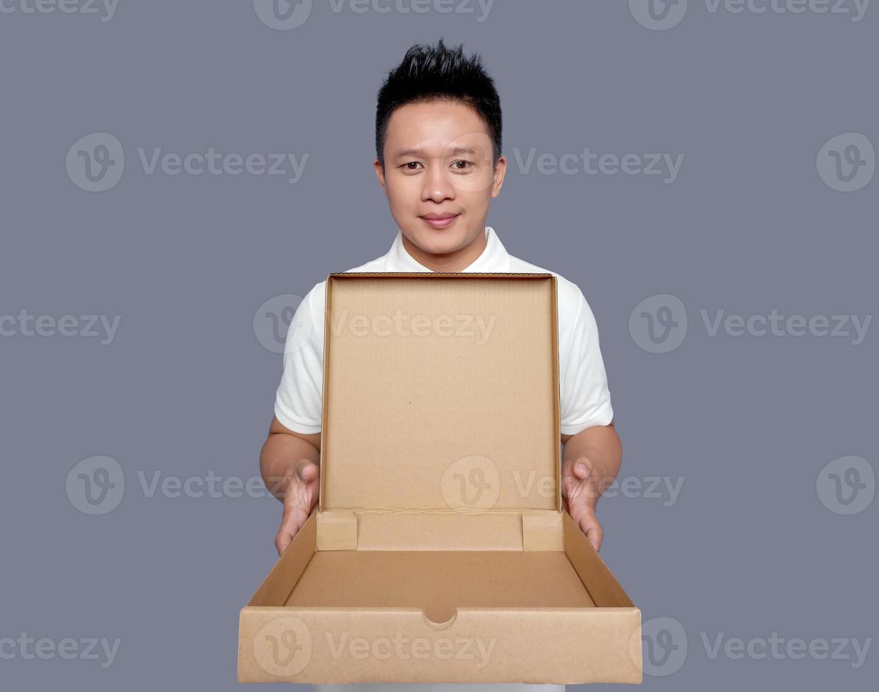 Man holding and opening empty pizza box isolated on plain background photo