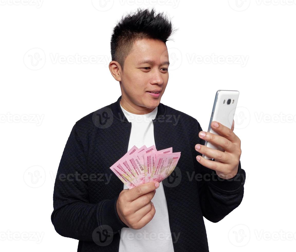 hermoso hombre participación teléfono inteligente y participación uno cien mil rupia indonesio dinero foto