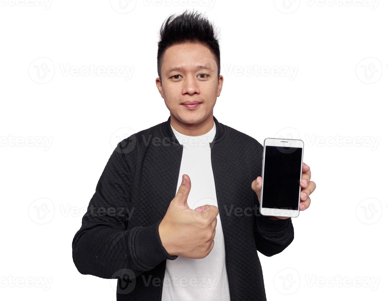 Casual man holding and showing mobile phone screen with thumbs up gesture. photo