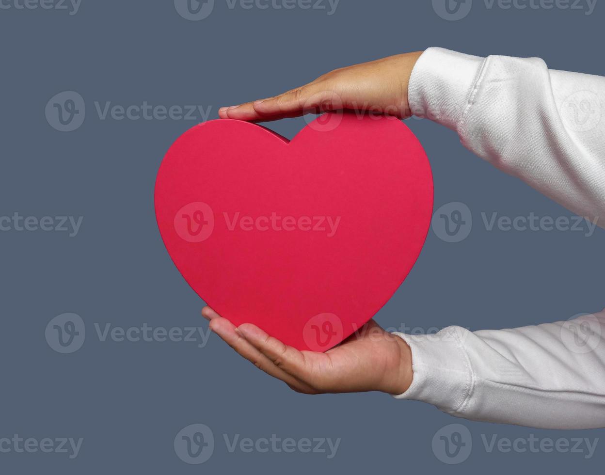 Man hand holding red heart shape isolated on plain background. photo