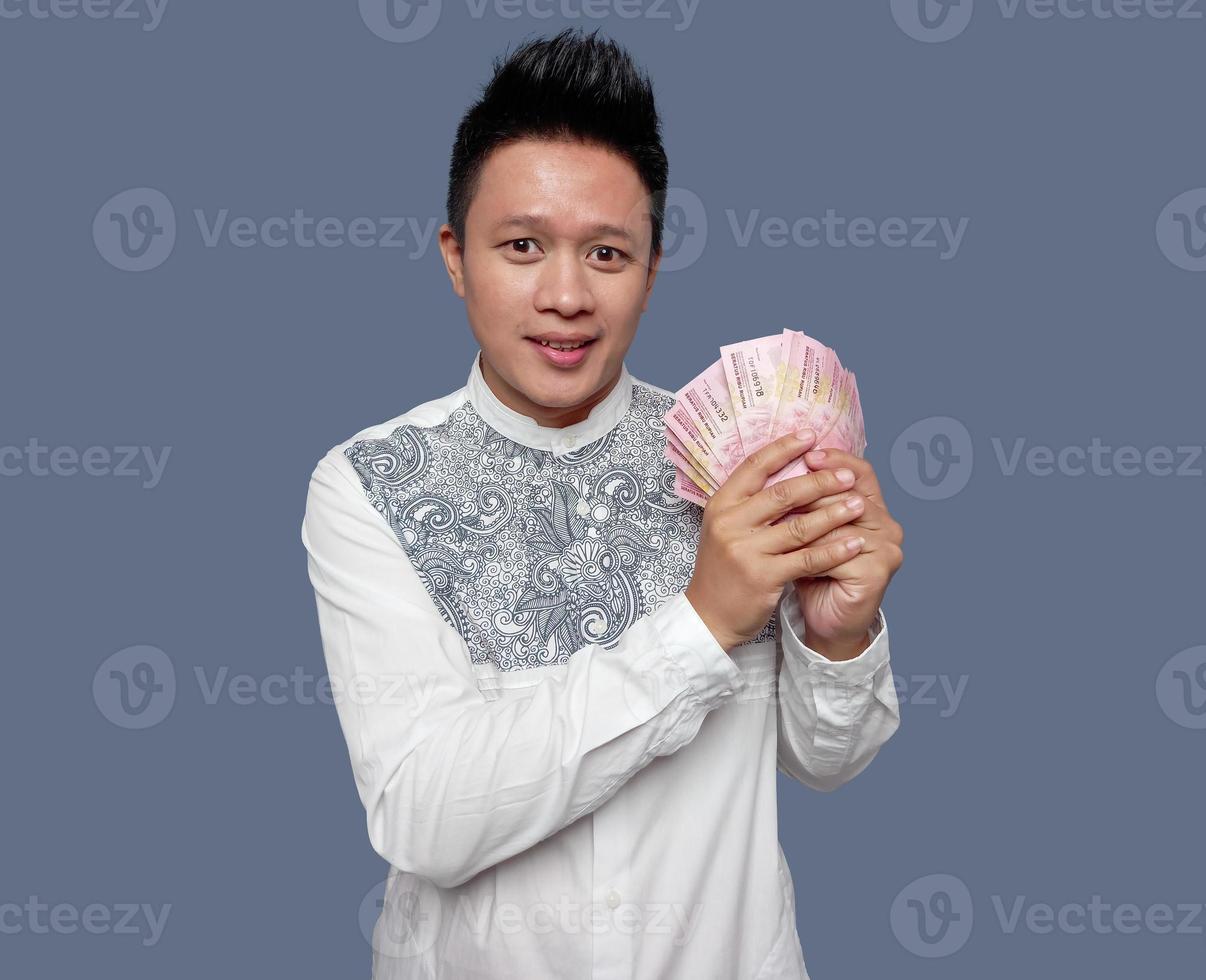 Handsome man holding a lot of one hundred thousand Indonesian rupiah photo