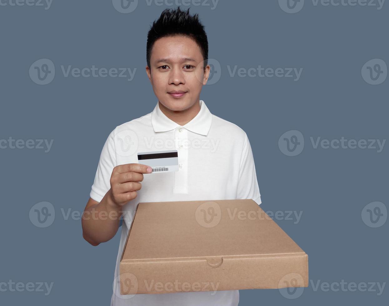 Man holding brown cardboard box and credit card isolated on plain background. photo