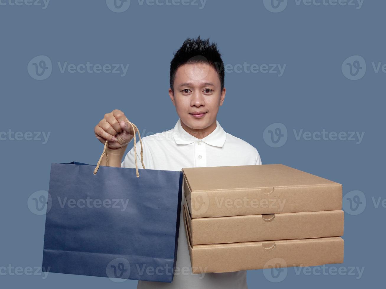 Man holding cardboard boxes and shopping bags isolated on plain background photo