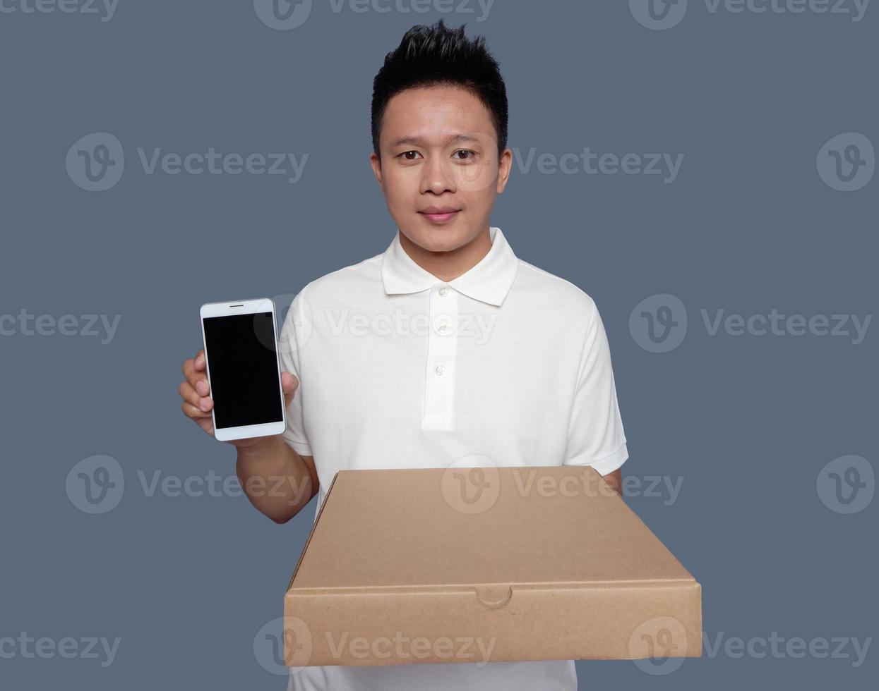 Man wearing collar shirt holding cardboard box and smartphone front view. photo