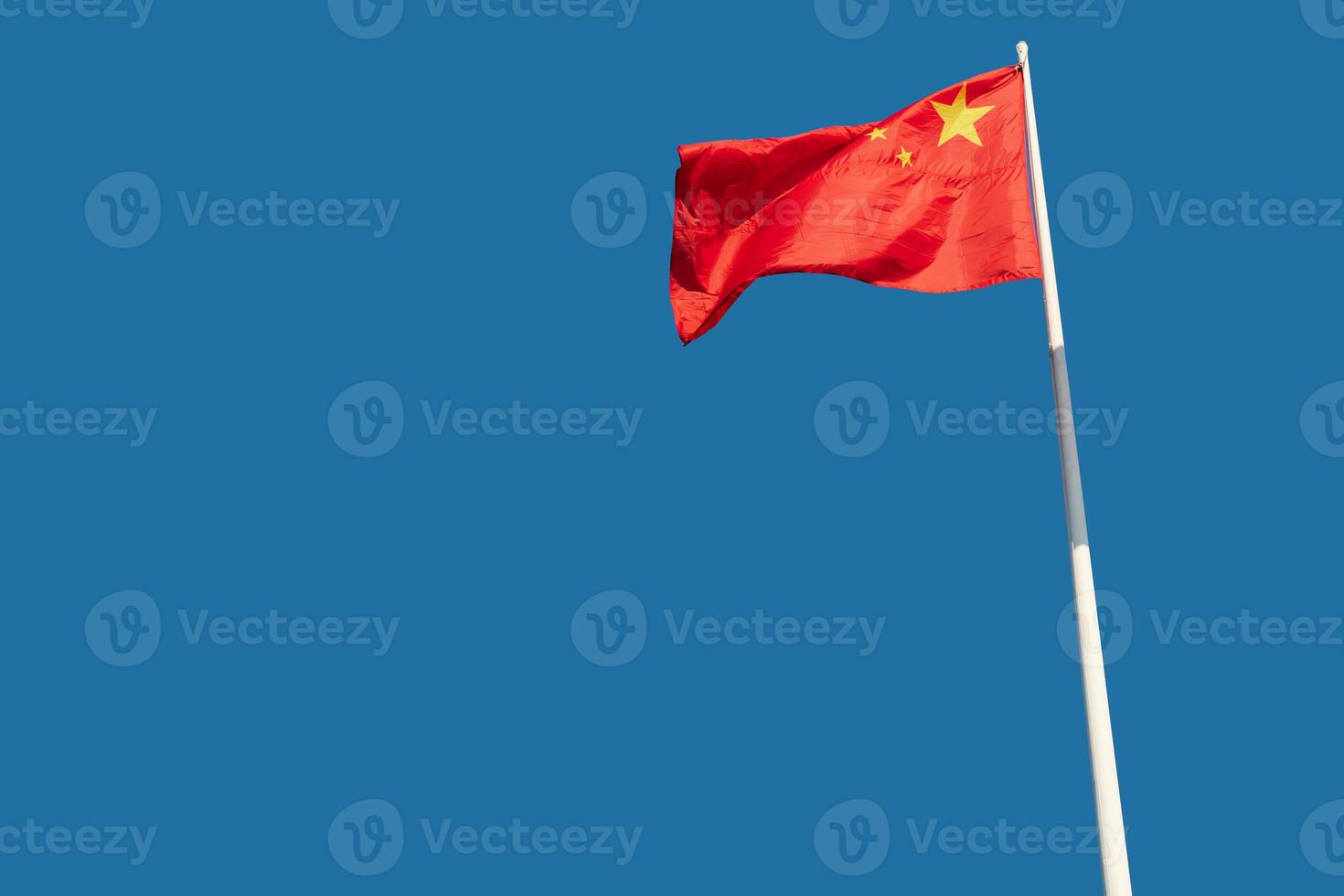 The national flags of China flutter against a blue sky. photo