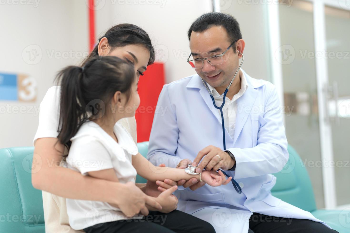 The pediatrician examined the health of the girl photo