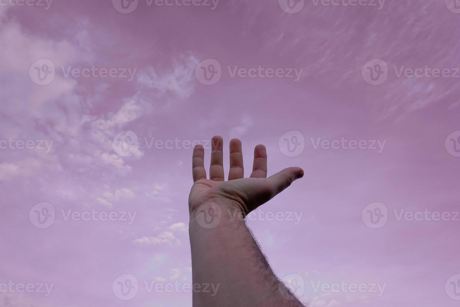 mano arriba gesticulando en el rosado cielo, sentimientos y emociones foto