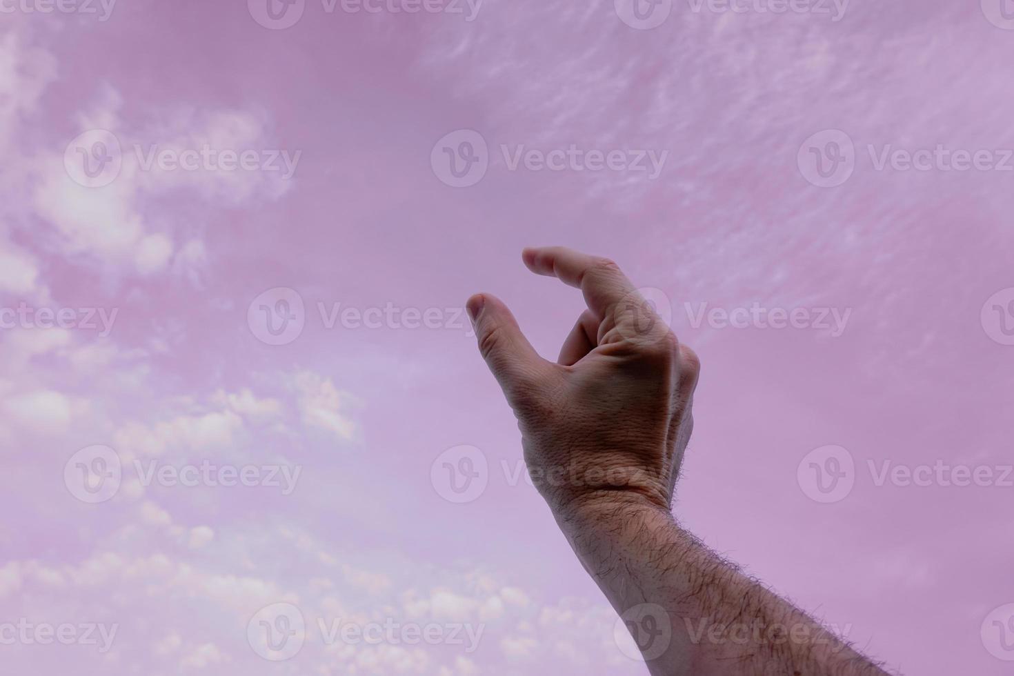 mano arriba gesticulando en el rosado cielo, sentimientos y emociones foto