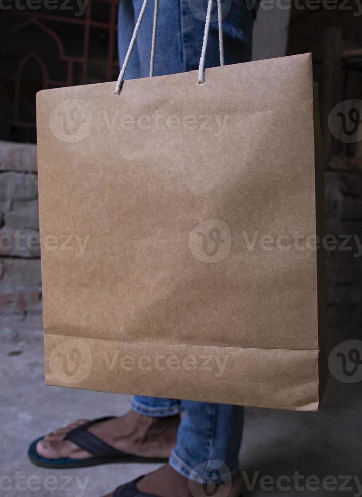 Closeup of a man holding a brown paper bag with copy space photo