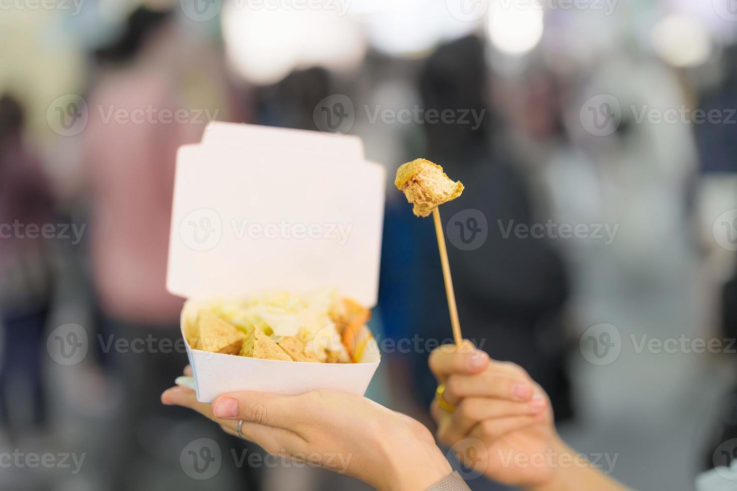 woman hand holding Stinky Tofu at night market, famous Taiwanese Street Food of Taiwan. exotic food in local market photo