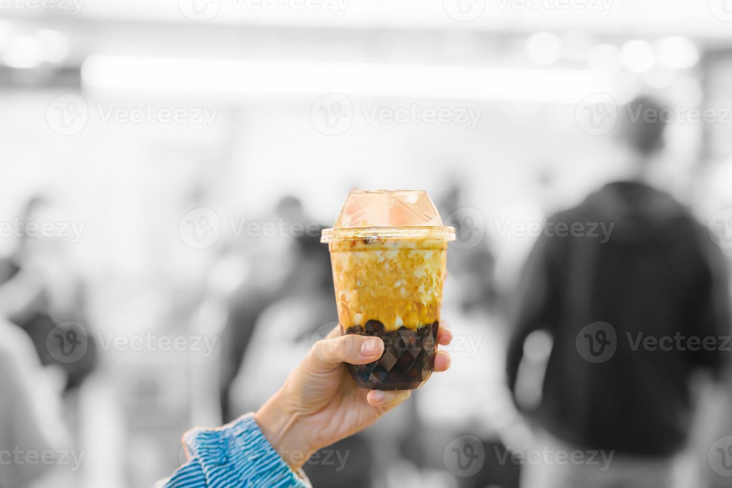 woman hand holding brown sugar boba milk tea with tapioca pearls at night market, famous Taiwanese bubble tea of Taiwan. Street Food and travel in Ximending, Taipei concept photo
