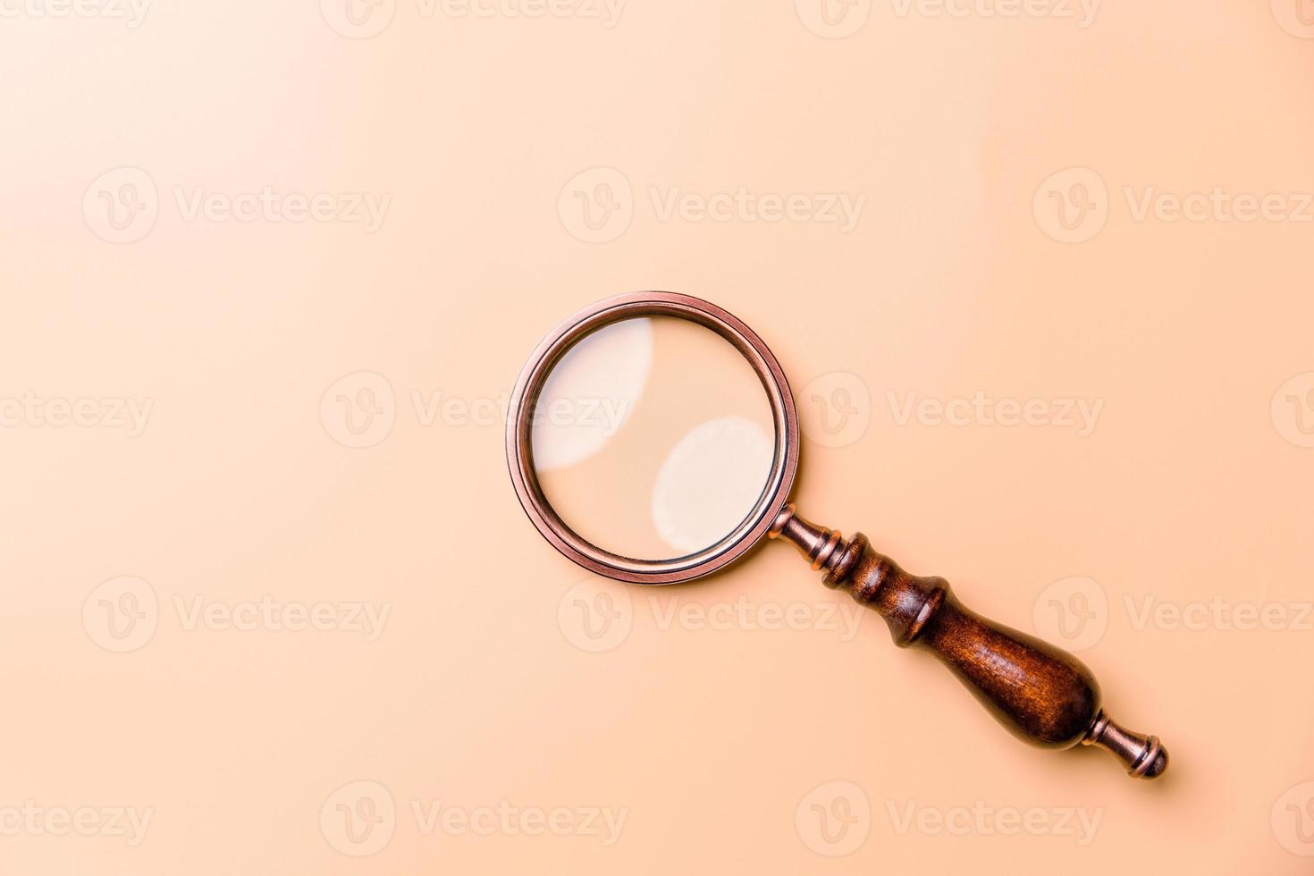 Magnifying glass on orange background. Top view. Flat lay. Copy space. Minimal creative concept. Blue background in pastel colours photo