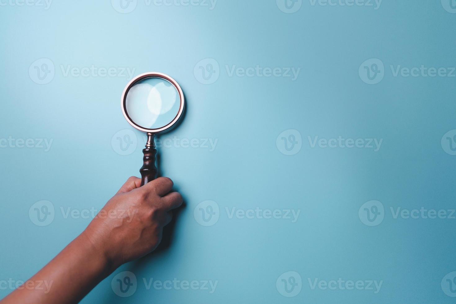 Magnifying glass on blue background. Top view. Flat lay. Copy space. Minimal creative concept. Blue background in pastel colours photo