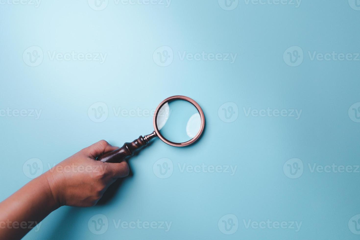 Magnifying glass on blue background. Top view. Flat lay. Copy space. Minimal creative concept. Blue background in pastel colours photo