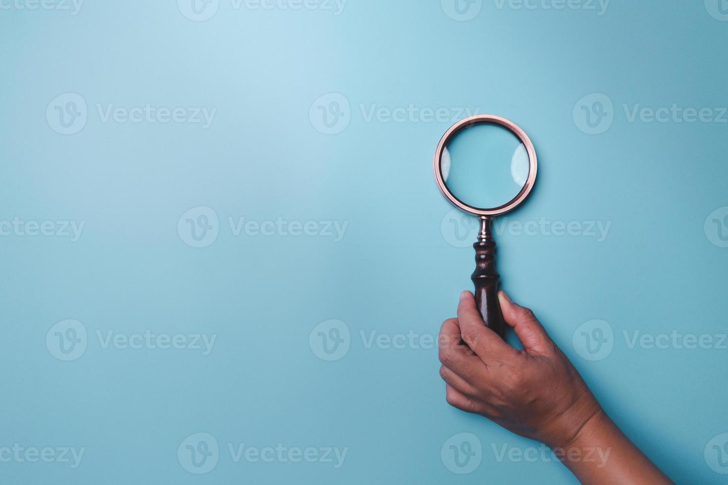 Magnifying glass on blue background. Top view. Flat lay. Copy space. Minimal creative concept. Blue background in pastel colours photo