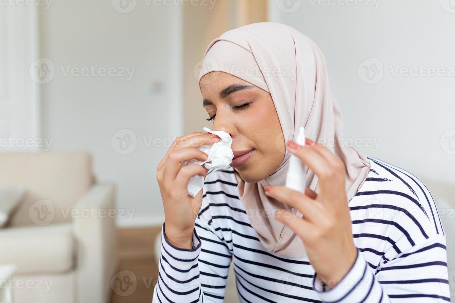 enfermo Arábica mujer con hijab es utilizando nasal rociar debido a el problemas con nariz y respiración foto