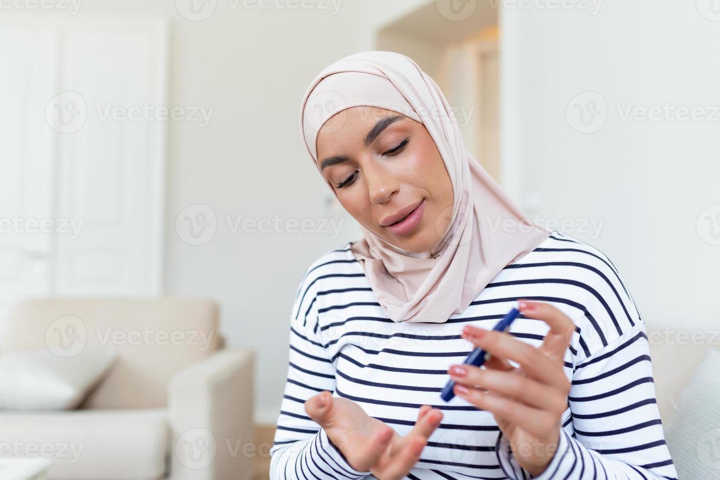 Arabic woman using lancet on finger for checking blood sugar level by Glucose meter, Healthcare and Medical, diabetes, glycemia concept photo