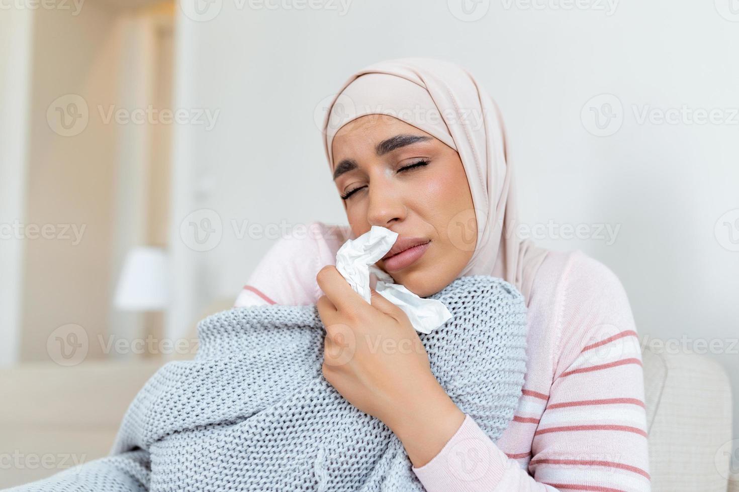 Sickness, seasonal virus problem concept. Arabic woman being sick having flu lying on bed. Sick woman with hijab lying in bed with high fever. Cold flu coronavirus, covid19 photo