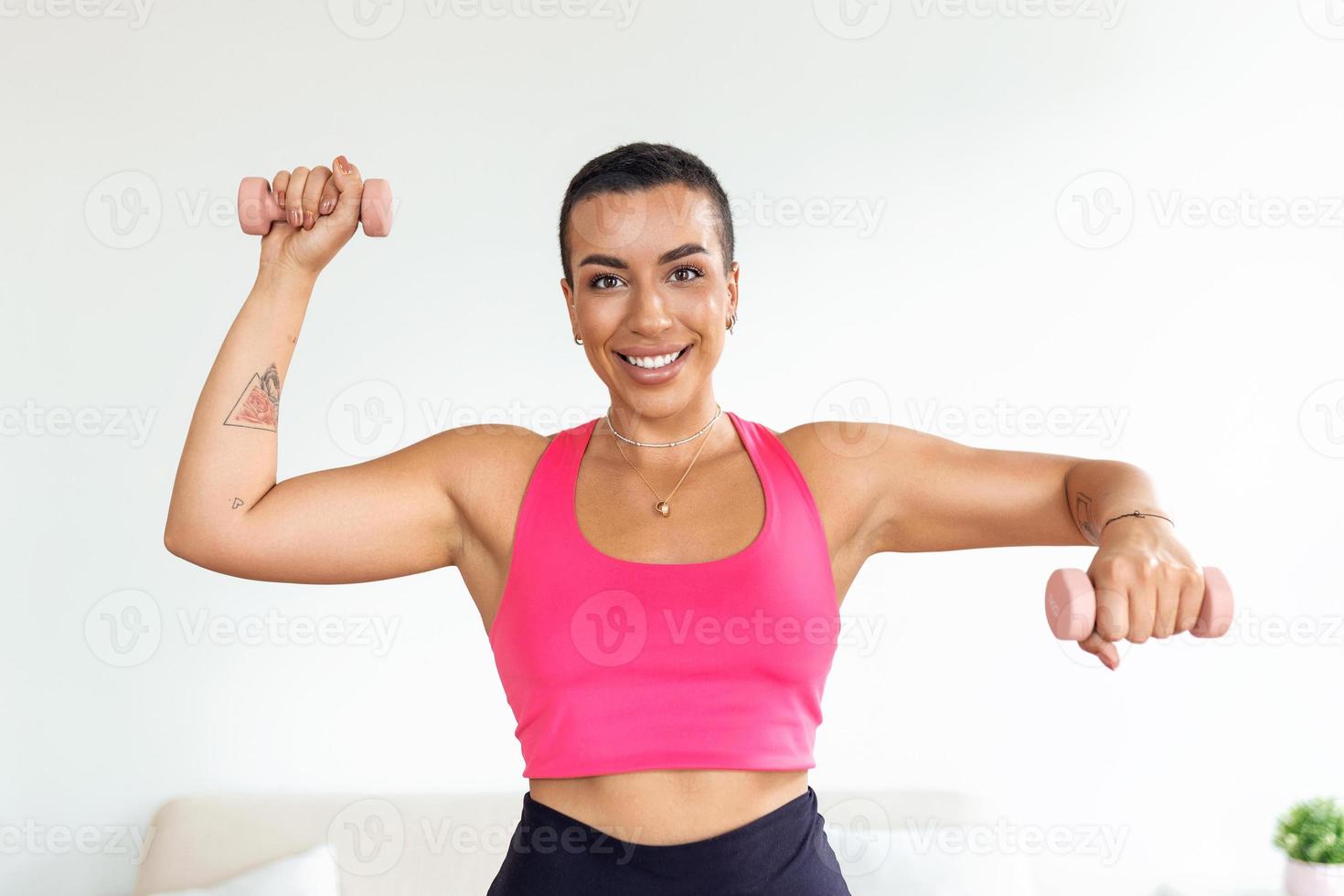 Domestic Training With Weights. Positive black lady doing exercises with dumbbells, strengthening her body at home. Smiling young female working on her biceps muscles, staying healthy photo