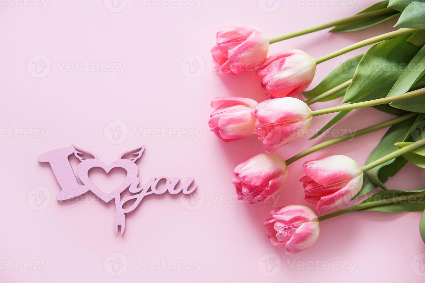 Pink Tulip flowers are arranged on a pink background. The view from the top, flat lay. Empty space for the text. Spring concept. Women's day. Mother's day. photo