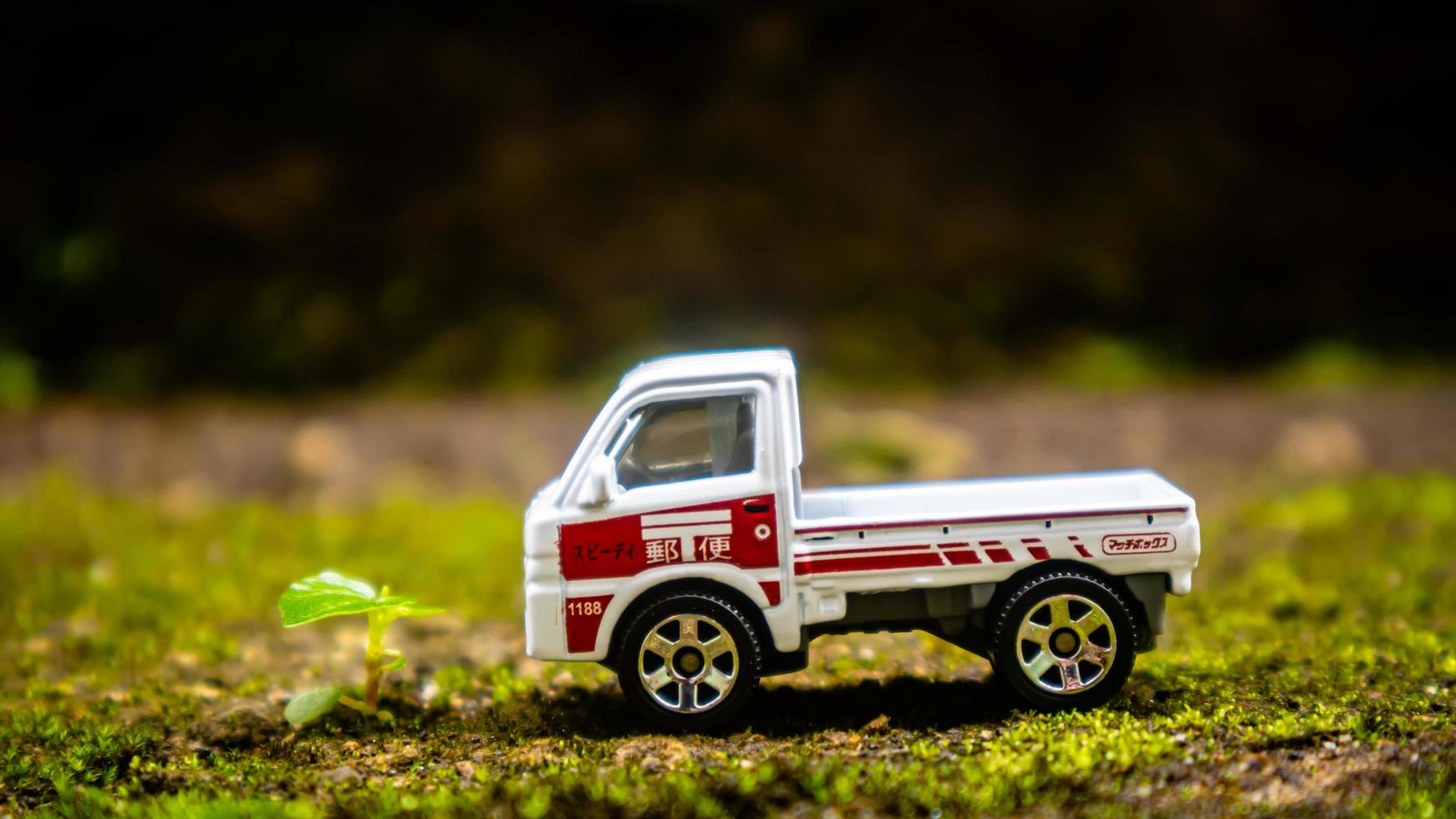 South Minahasa, Indonesia  January 2023, a toy car on a mossy floor that looks like grass photo