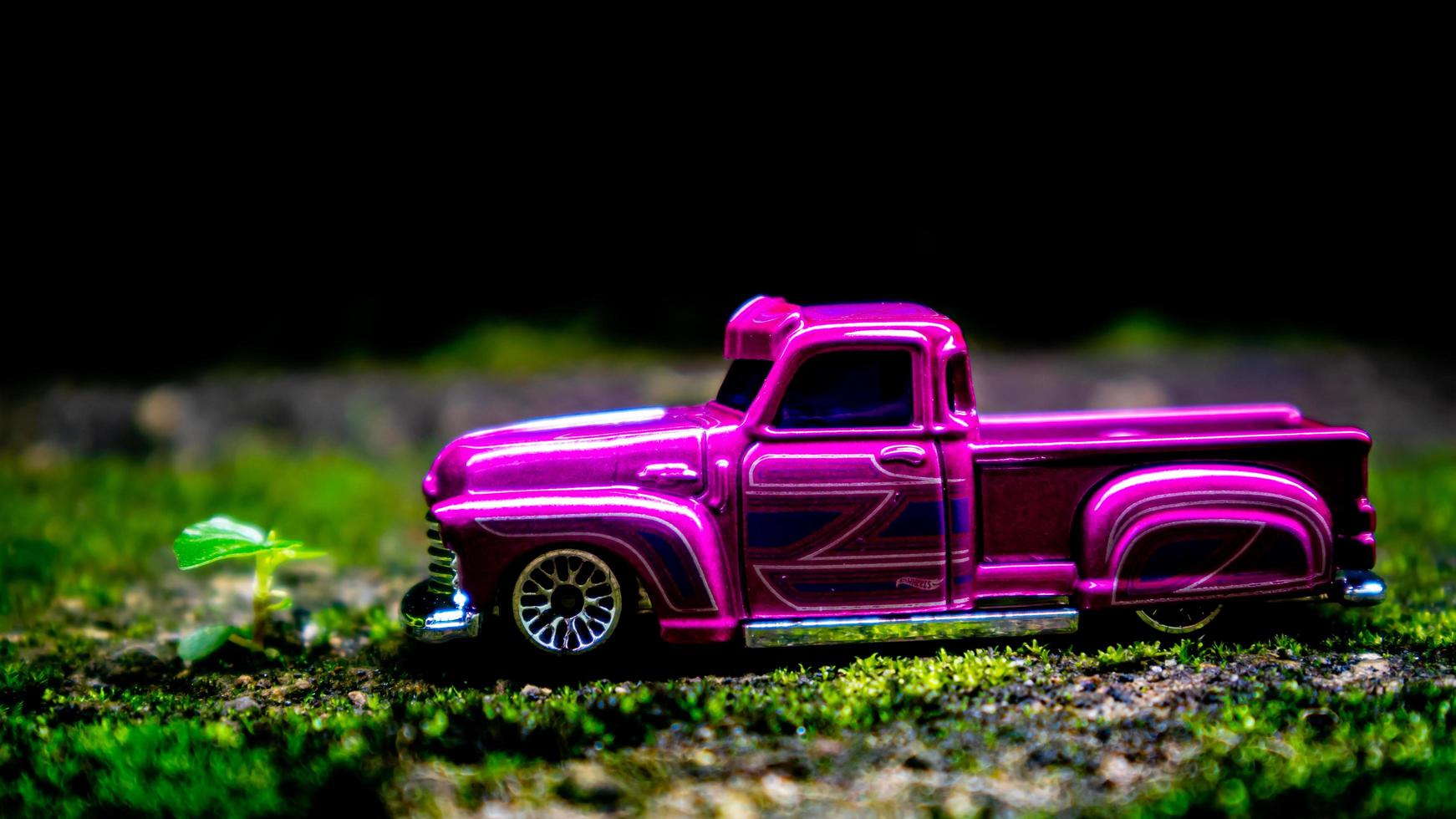 South Minahasa, Indonesia  January 2023, a toy car on a mossy floor that looks like grass photo