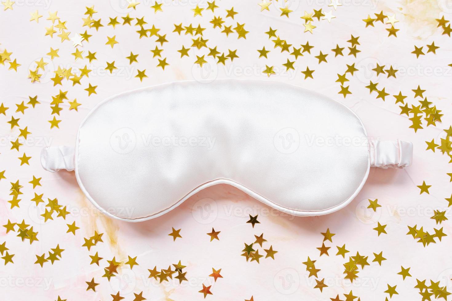 Pink satin eye sleeping mask and golden stars photo