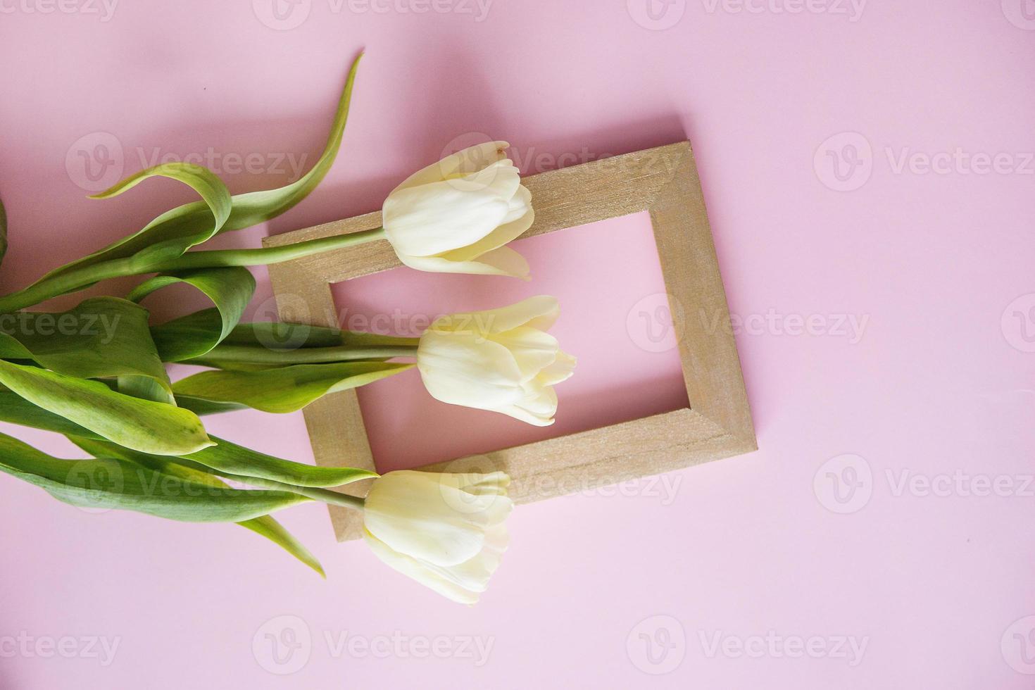 Yellow Tulip flowers are arranged on a pink background. The view from the top, flat lay. Empty space for the text. Spring concept. Women's day. photo
