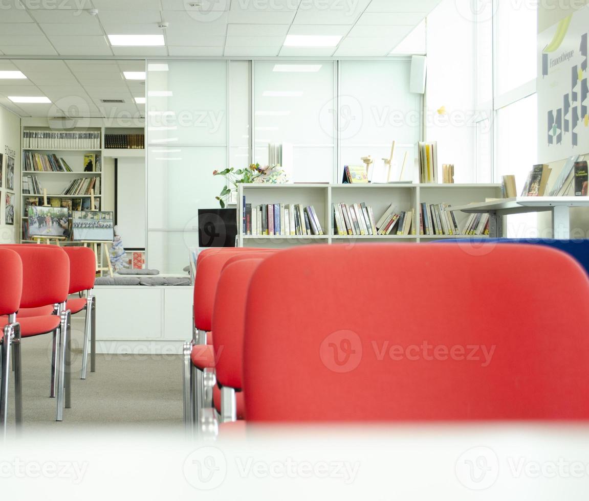 antes de un conferencia. vacío conferencia reunión espacio. rojo sillas y libros en el antecedentes. foto