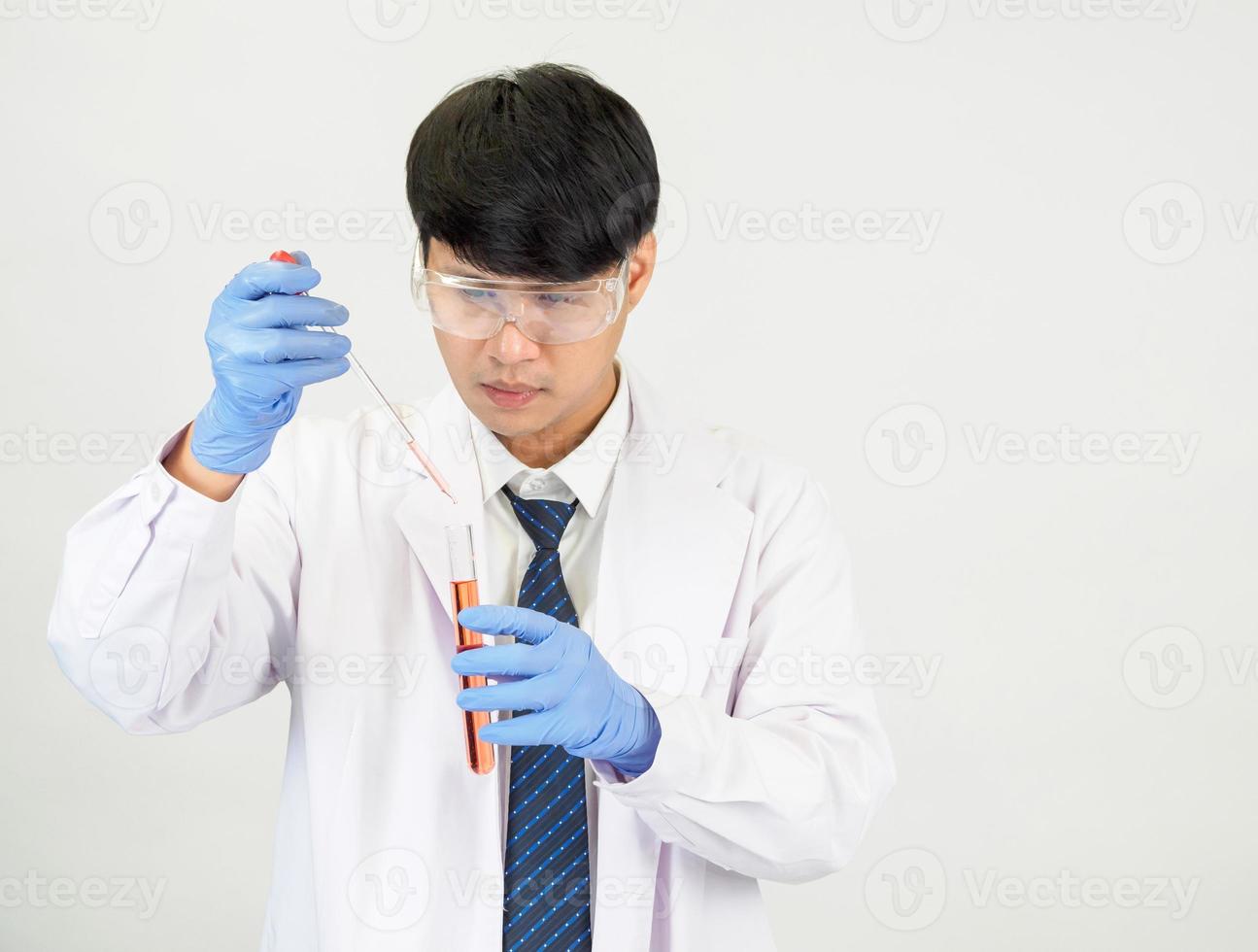 asiático hombre estudiante científico o médico en reactivo mezcla laboratorio en un Ciencias investigación laboratorio con prueba tubos de varios tamaños en el piso en laboratorio química laboratorio blanco antecedentes. foto