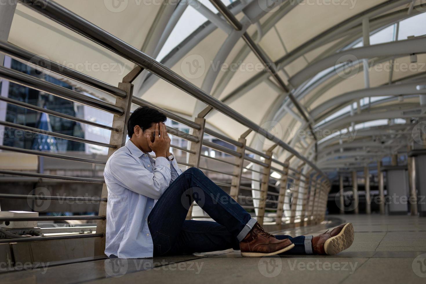 Broken heart man sitting down the street in sadness and despair due to economic crisis unemployment for financial issue failure and mental disorder problem concept photo