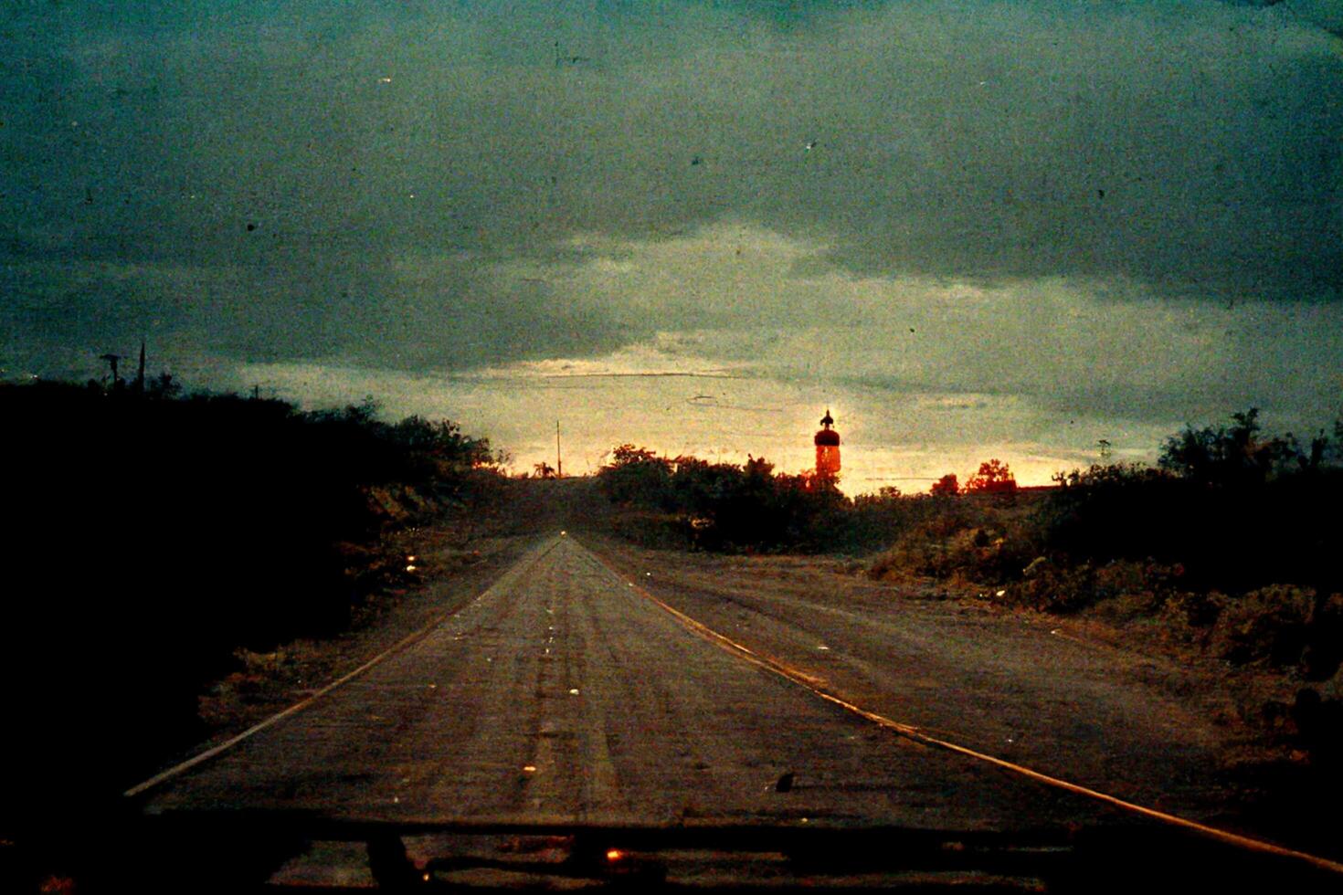 long empty road with a light house in the distance. . photo