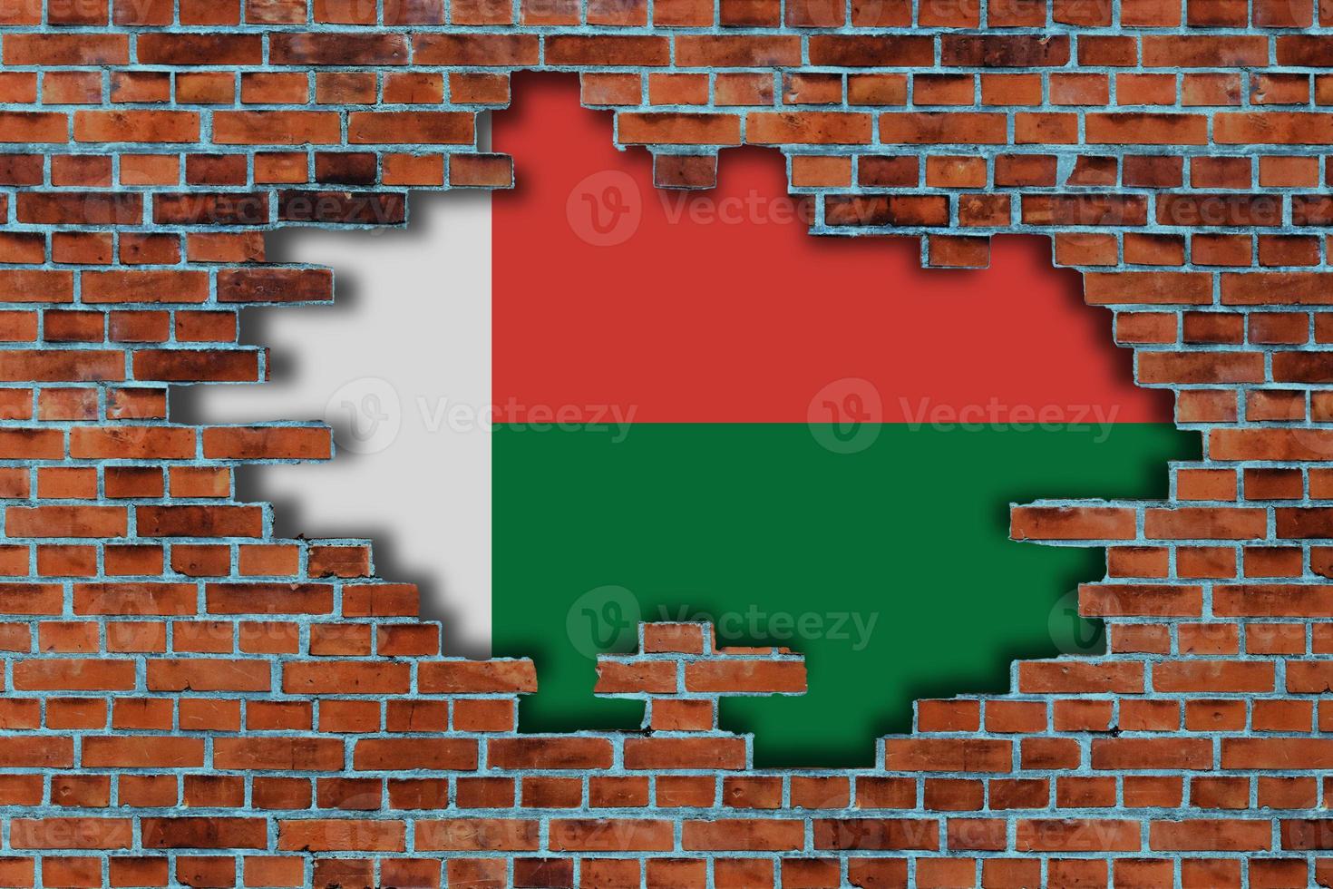 3D Flag of Madagascar behind the broken old stone wall background. photo