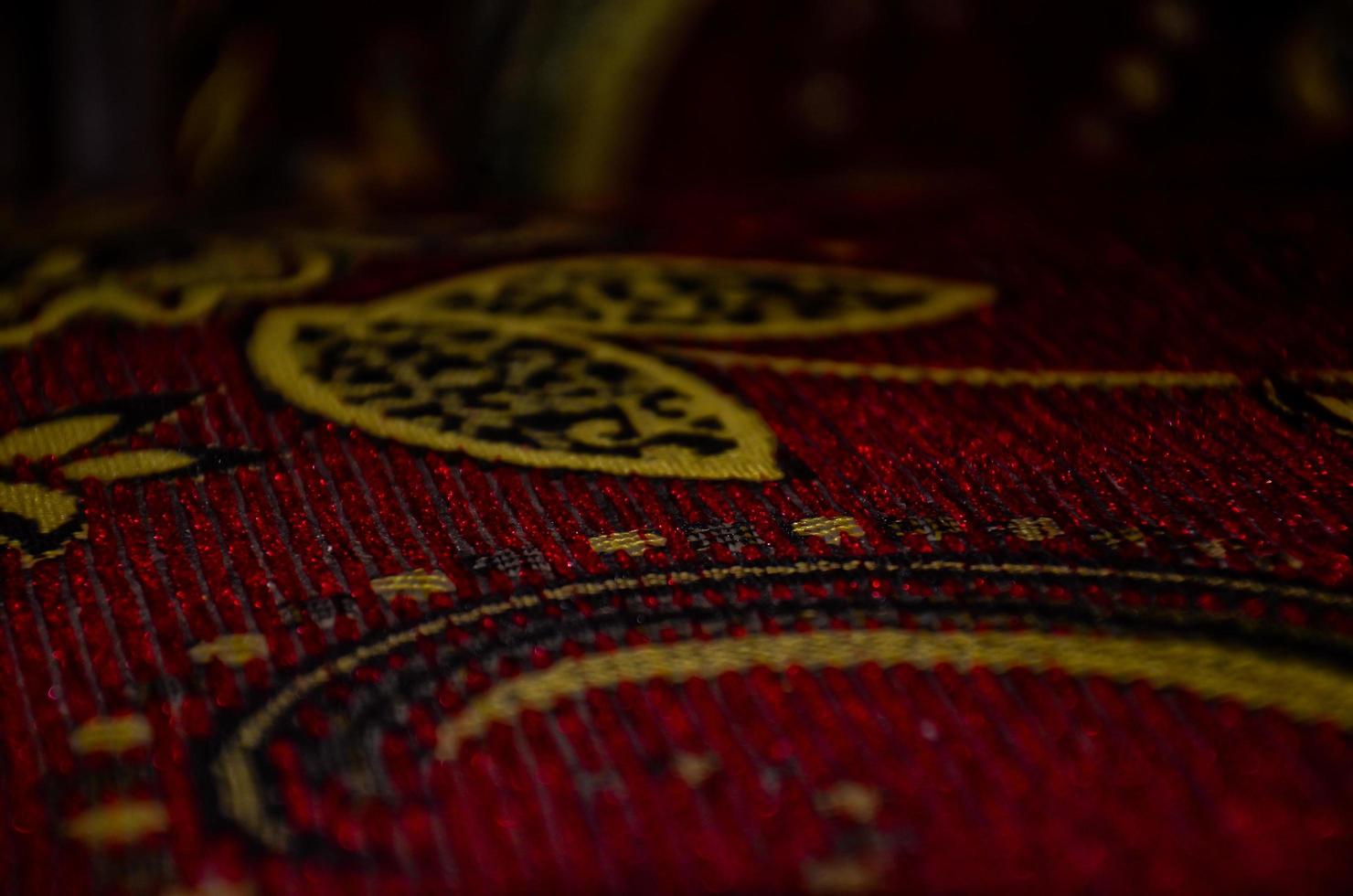 Abstract batik with plant motifs on a red fabric background photo