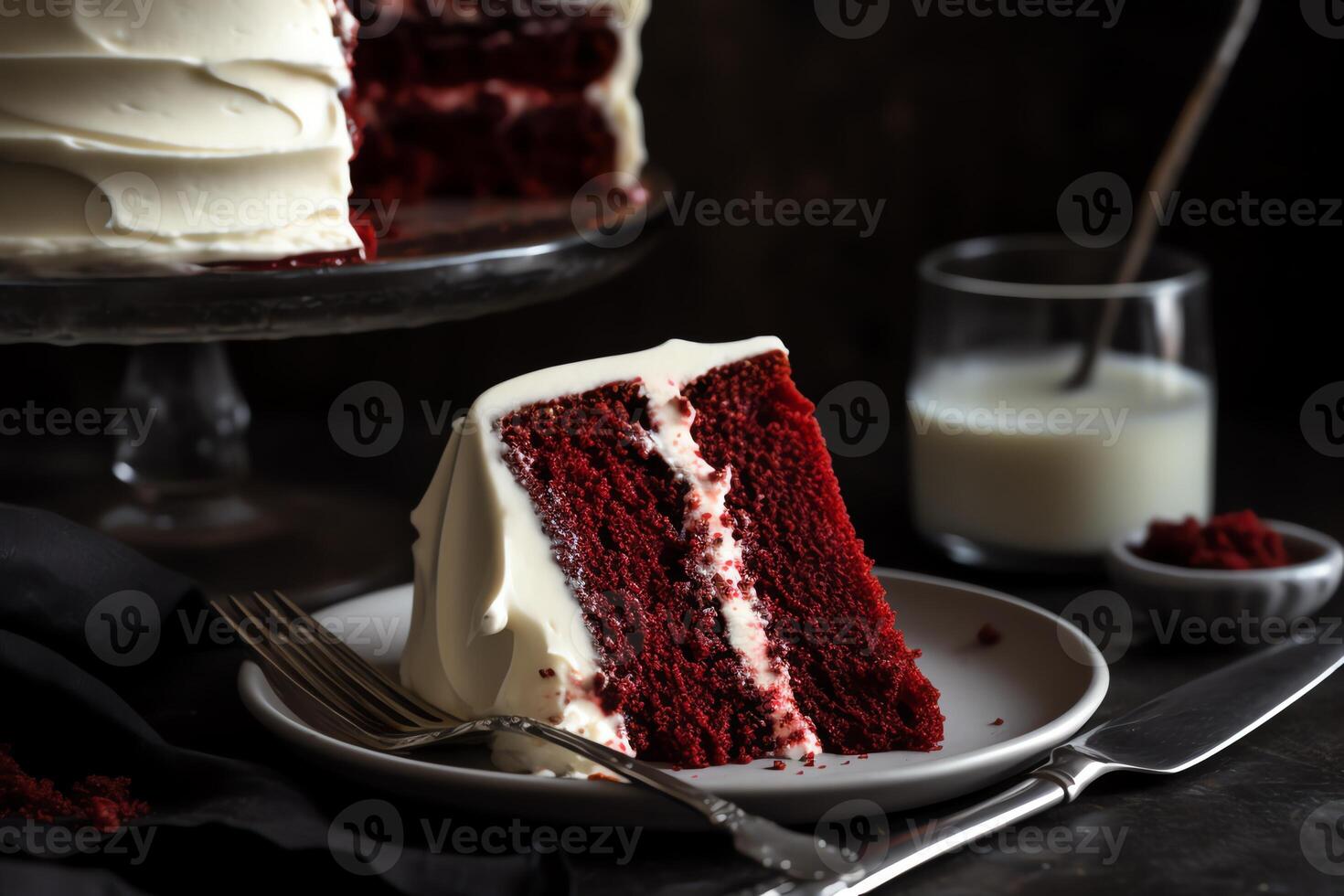 Red velvet cake slice with white frosting, fork, and red wine. photo