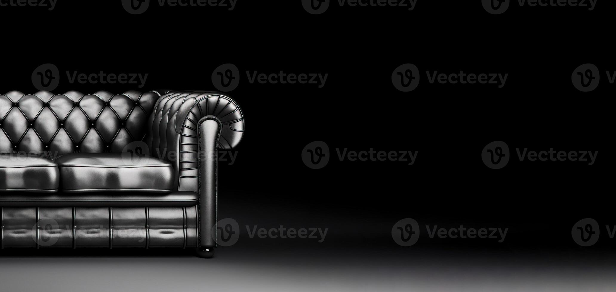 Chesterfield sofa made of black leather on a dark background, isolate. . photo