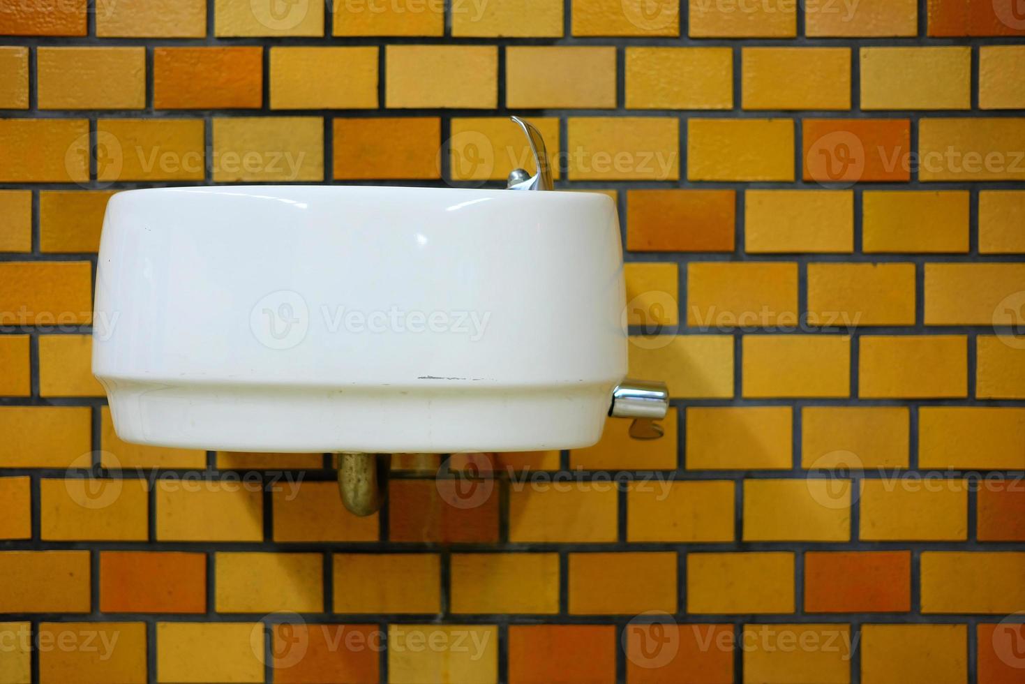 antiguo blanco cerámico lavabo en ladrillo pared. foto
