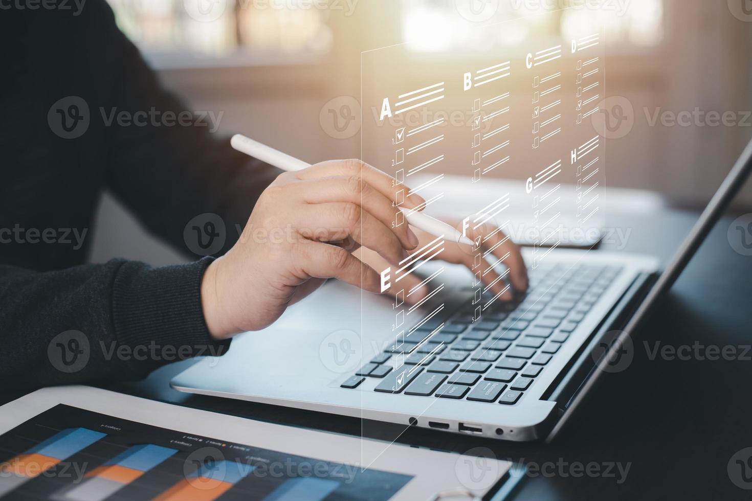 Businessman using a laptop and Taking an assessment, questionnaire, evaluation, online survey online exam Choosing the right answer in exam by filling out the online survey form,Answer  test questions photo